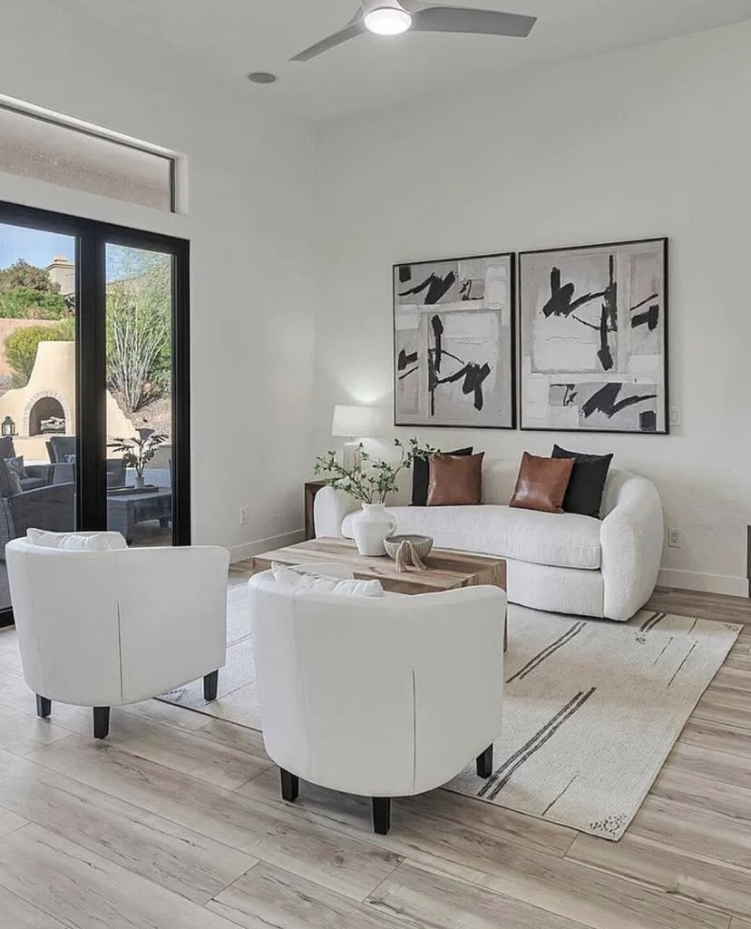 Staged family room in Peoria, Arizona with natural wood flooring, cozy fireplace, and stylish home décor
