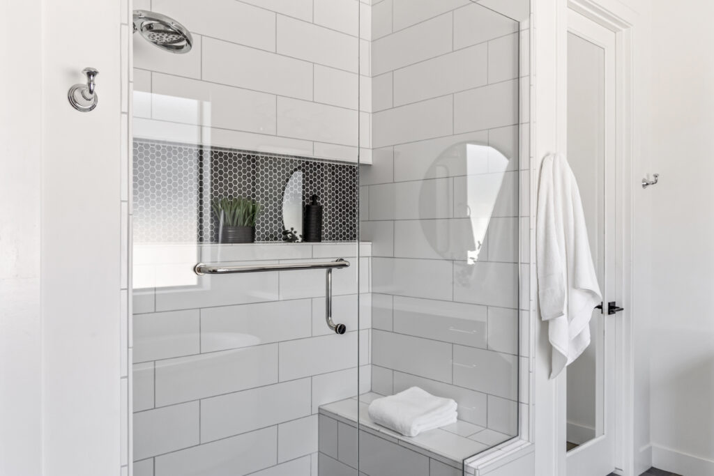 Newly renovated walk-in shower with modern tile, glass enclosure, and professional home staging in Arizona