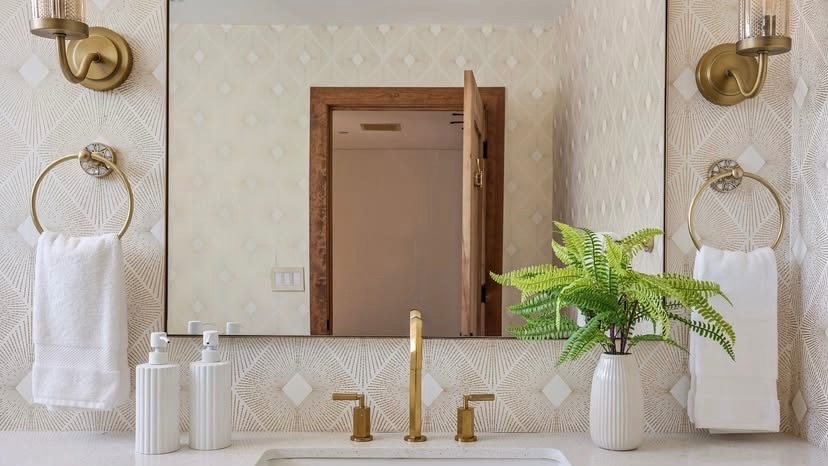 Anthro-inspired bathroom with gold fixtures and wallpaper